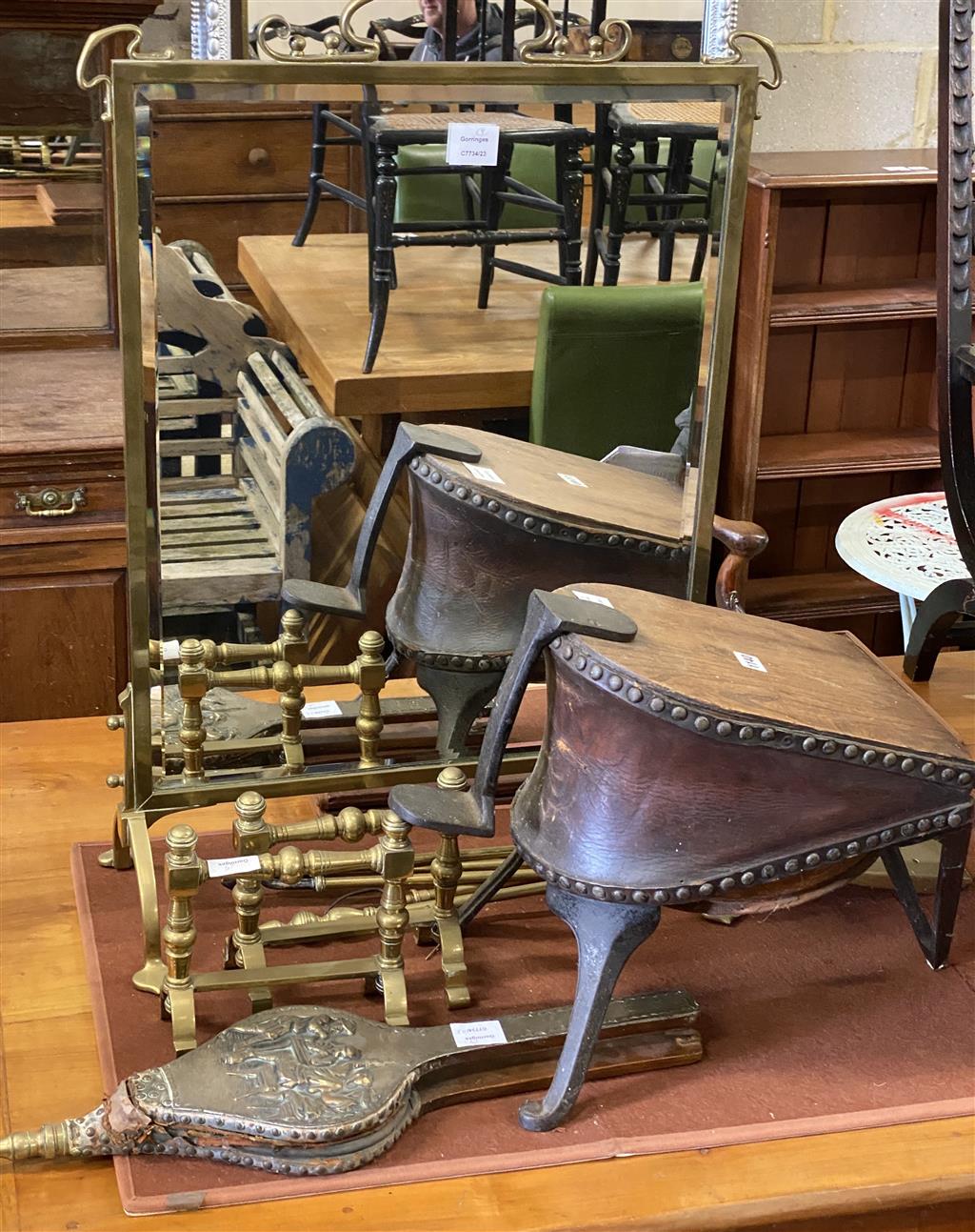A late Victorian brass framed mirrored firescreen, a pair of brass fire dogs, a pair of bellows, set of bellows ,four brass fire implem